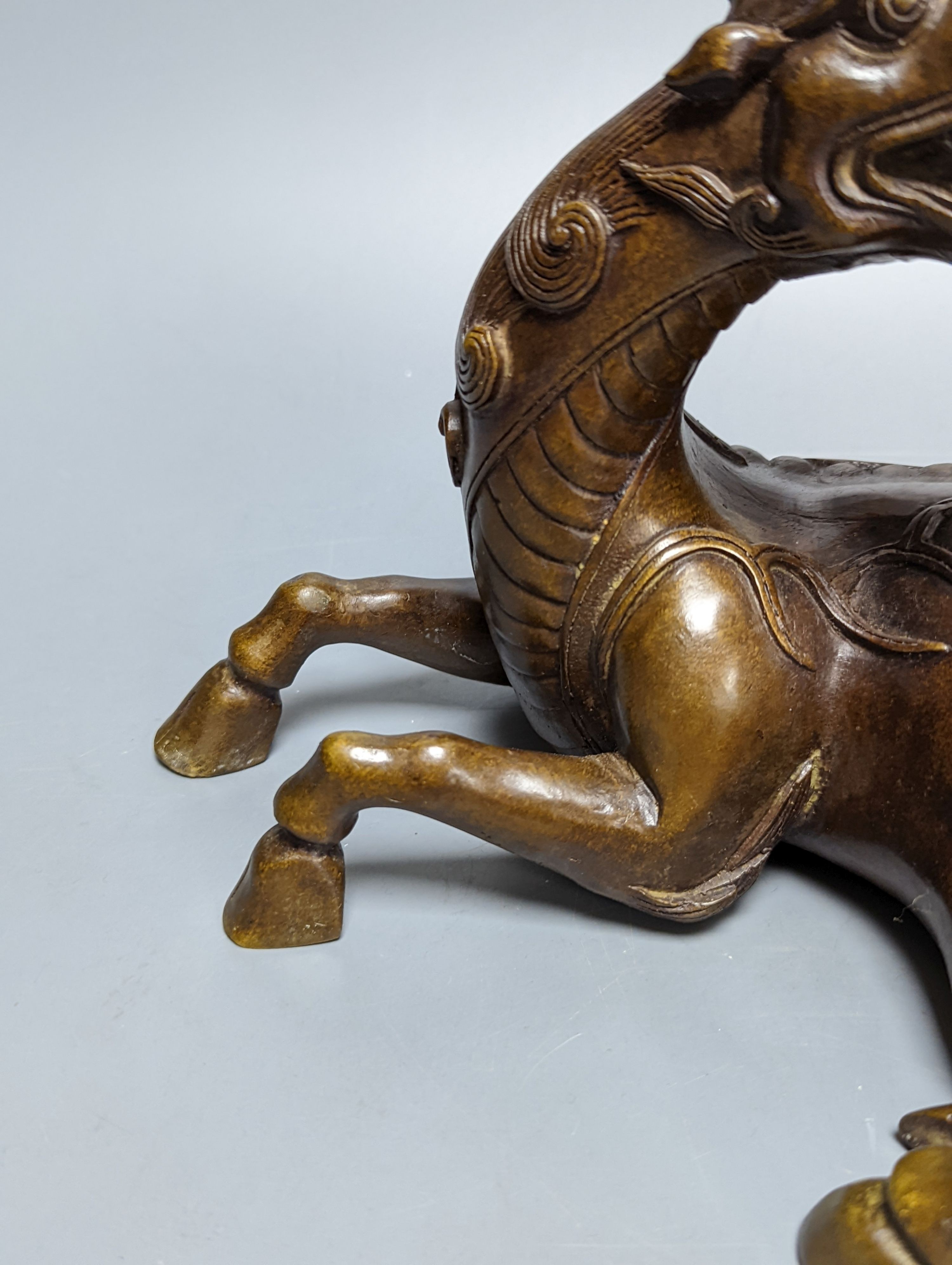 A Chinese parcel-gilt bronze incense burner and cover, modelled as a recumbent qilin, Qing dynasty, 19th century, 25 cms wide.